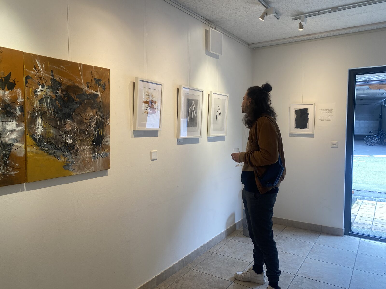 Gallery view of framed drawings and a large mixed-media canvas at the Présence/Absence exhibition.